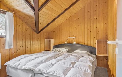 a large bed in a room with wooden walls at Beautiful Home In lsted With Kitchen in Ølsted