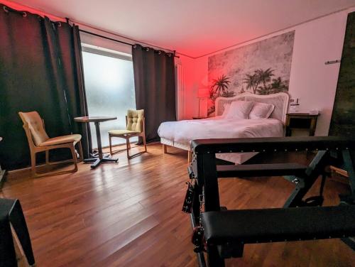 Jacuzzi LOVE appartement في باريس: غرفة نوم بسرير وطاولة وكراسي