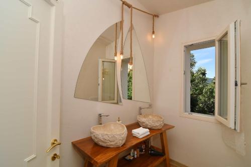 a bathroom with two granite sinks and a window at Amoreddu in San Teodoro