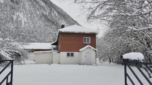 una casa cubierta de nieve frente a una valla en Le Valentin, en Eaux-Bonnes