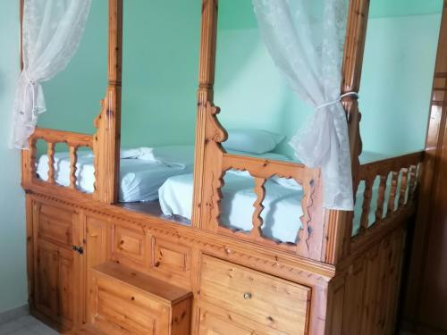 1 dormitorio con cama de madera y dosel en oasis studio en Diafani