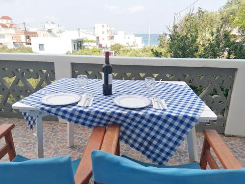 una mesa con una botella de vino en el balcón en oasis studio, en Diafani