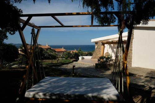 a bed in a yard with the ocean in the background at Amoreddu in San Teodoro