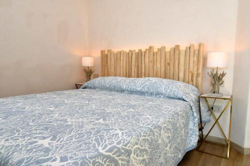 a bedroom with a bed with a blue and white comforter at Amoreddu in San Teodoro
