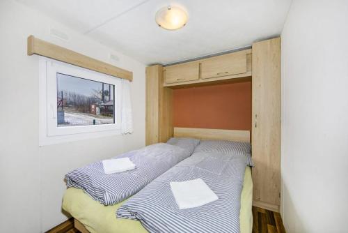 two beds in a room with a window at Ubytování v přírodě Plzeňsko in Kaznějov