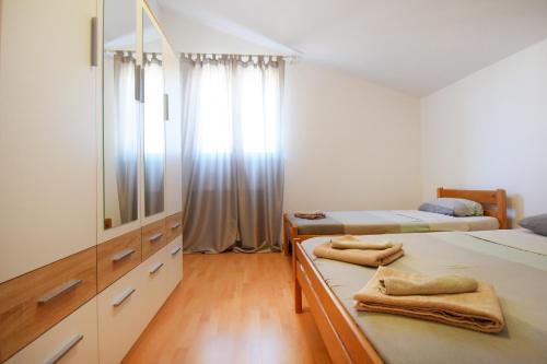 a bedroom with two beds and a dresser and a mirror at Suitable Summer Apartments in Pula