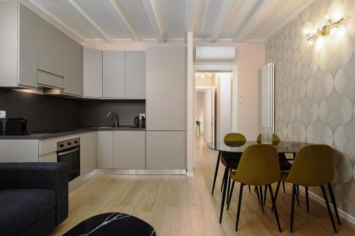 eine Küche und ein Esszimmer mit einem Tisch und Stühlen in der Unterkunft Classbnb - Bilocale di design in zona Sempione in Mailand