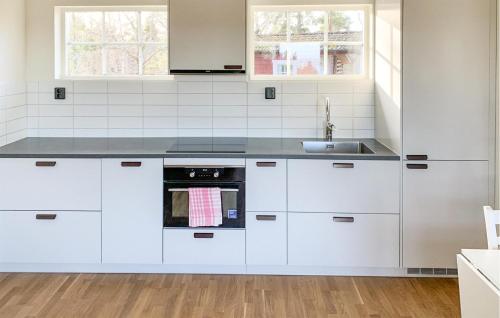 una cocina con armarios blancos y fregadero en Amazing Home In Mariefred With Kitchen en Mariefred