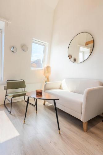 un salon avec un canapé blanc et une table dans l'établissement Emplacement central pour ce studio Vieux Lille, à Lille