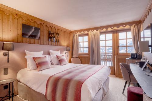 Habitación de hotel con cama grande y escritorio. en La Ferme du Golf en Megève