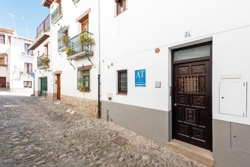una puerta en un edificio blanco en una calle adoquinada en Apartamentos Bravo by A3 Rentals, en Granada