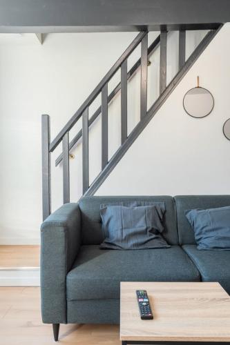 - un salon avec un canapé bleu et un escalier dans l'établissement Charmant appartement rénové 2 chambres., à Marcq-en-Barœul