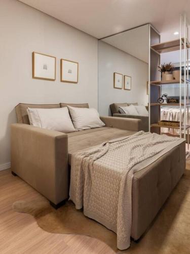 a bedroom with a large bed with a blanket on it at Studio 313 Parque Una in Pelotas