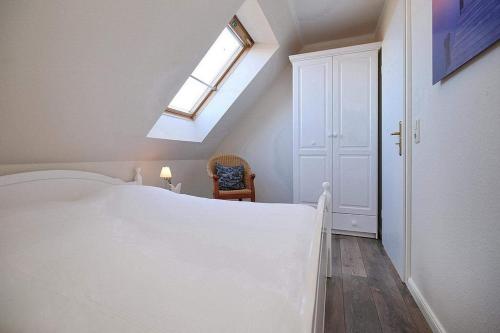 a bedroom with a white bed and a skylight at Ferienwohnung Papillon Boltenhagen in Boltenhagen
