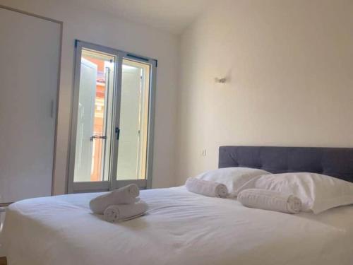 - un lit blanc avec des serviettes et une fenêtre dans l'établissement forcioli conti T2 tout confort, à Ajaccio