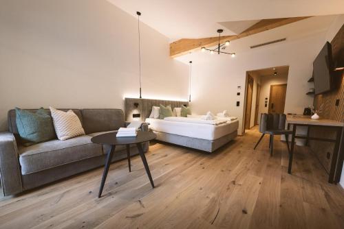 ein Wohnzimmer mit einem Sofa und einem Bett in der Unterkunft Ferienwelt Kesselgrub Hotel in Altenmarkt-Zauchensee in Altenmarkt im Pongau