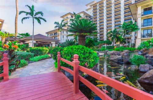 a wooden bridge over a koi pond at a resort at Ko Olina Beach Villas O704 in Kapolei