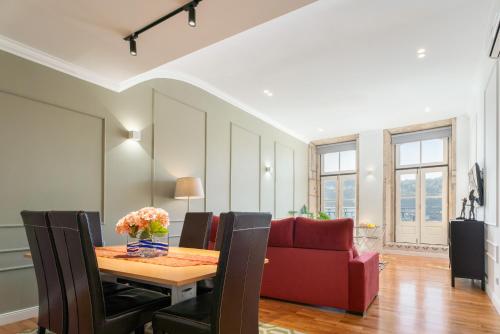 a dining room with a table and a red couch at Apartamento Premium Douro River Views in Porto