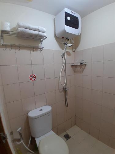 a small bathroom with a toilet and a shower at Pleasant6tifolia in Jakarta