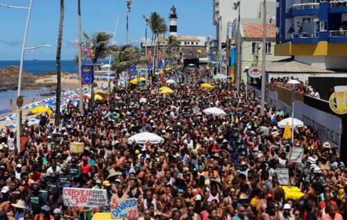 uma grande multidão de pessoas numa praia com guarda-sóis em Lugar para casal na Barra. em Salvador