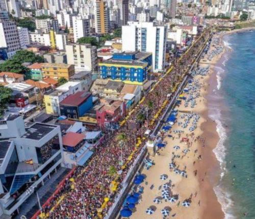 uma multidão de pessoas numa praia perto do oceano em Lugar para casal na Barra. em Salvador