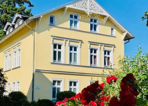 ゲーレンにあるVilla Granitz - Ferienwohnung 45466 (Sassnitz)の赤い花の黄色い家
