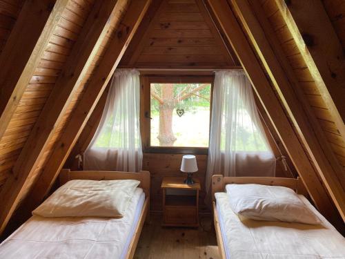 two beds in a attic bedroom with a window at SOLO in Łukęcin