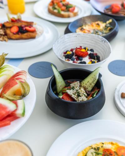 a bunch of plates of food on a table at DeLight Boutique Hotel - Small Luxury Hotels of the World in Agios Ioannis Mykonos