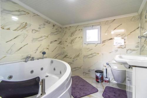 La salle de bains blanche est pourvue d'une baignoire et d'un lavabo. dans l'établissement Villa Şans, à Fethiye