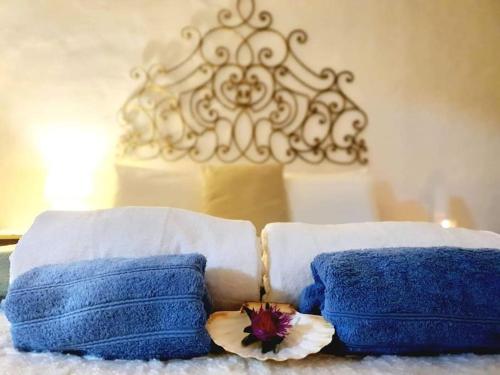 Dos toallas azules y una flor en una cama. en Casa de Danann, en Rasquera