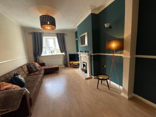 a living room with a couch and a fireplace at Spacious Seaside House in Cleethorpes