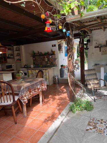 eine Terrasse mit einem Tisch und Stühlen in einem Zimmer in der Unterkunft Casa Mico Leão Dourado in Bombinhas