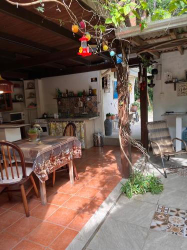 a patio with a table and chairs in a room at Casa Mico Leão Dourado in Bombinhas