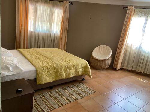 a bedroom with a bed and a table and a window at Vacation Home close to the beach in Bilene in Vila Praia Do Bilene