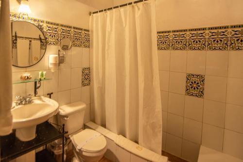 a bathroom with a toilet and a sink and a shower at El Beaterio Casa Museo in Santo Domingo