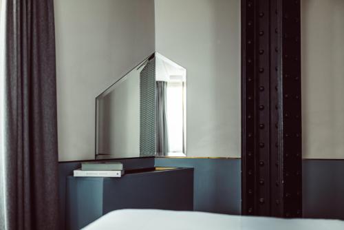 a bedroom with a mirror and a bed at Hotel Panache in Paris