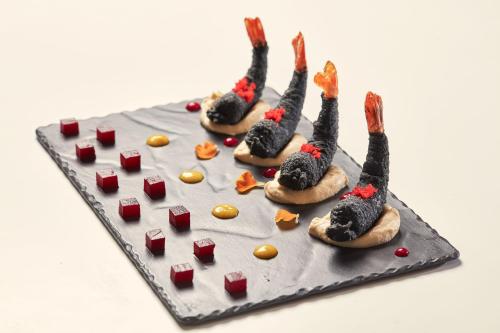 a cake with a group of food on a table at DeLight Boutique Hotel - Small Luxury Hotels of the World in Agios Ioannis Mykonos