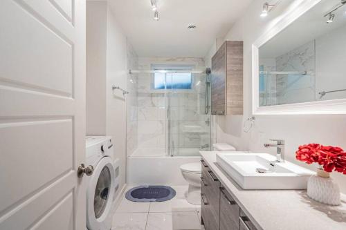 biała łazienka z umywalką i toaletą w obiekcie Free Parking - Best Travel by Zen Living w mieście Longueuil