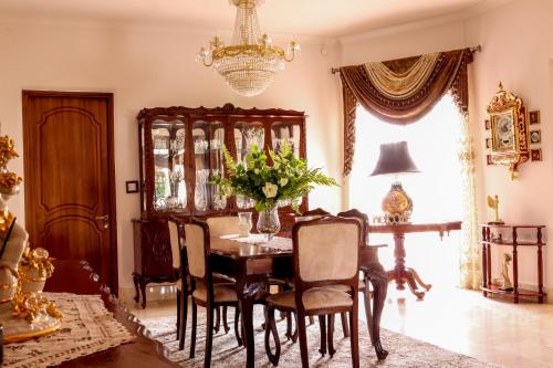 uma sala de jantar com uma mesa e cadeiras e um lustre em Madonnina Homestay em St. Julian's