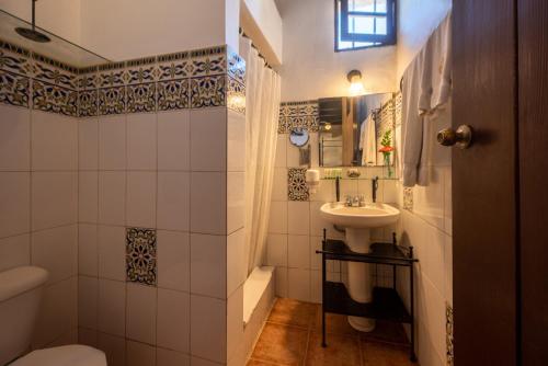a small bathroom with a sink and a toilet at El Beaterio Casa Museo in Santo Domingo