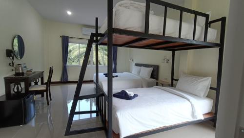 a bedroom with two bunk beds and a desk at Khao Sok Green Garden Resort in Khao Sok