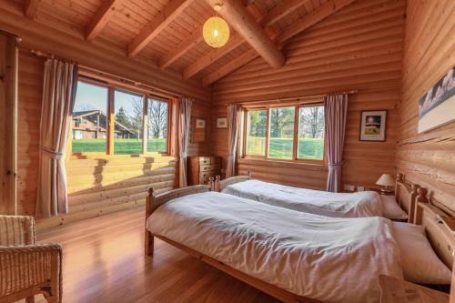 a bedroom with two beds in a log cabin at Pinecroft Lodges in Ingleton