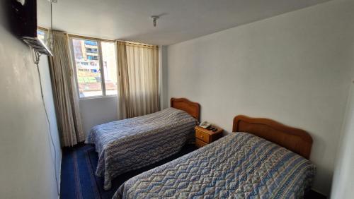 杜伊塔马Hotel Catalina Real的有两张床和一扇窗户的酒店房间
