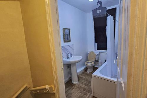 a bathroom with a sink and a toilet and a tub at Affordable Private Space in Leeds