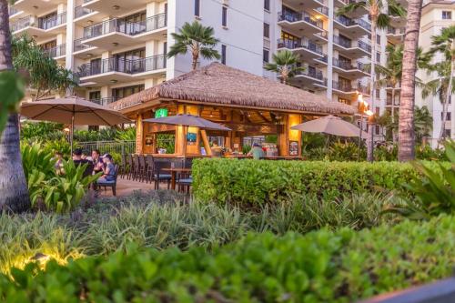 a restaurant with people sitting at tables and umbrellas at Ko Olina Beach Villas O805 in Kapolei