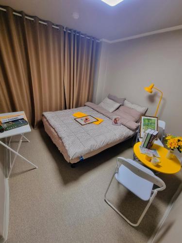 Taereung stay في سول: غرفة نوم صغيرة بسرير وطاولة صفراء