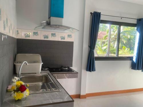 uma cozinha com um lavatório e uma janela em บ้านระเบียงเลหลังสวน 1 ห้อง em Ban Hin Sam Kon