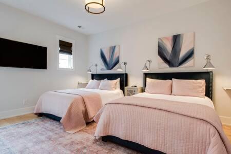 a bedroom with two beds and a flat screen tv at The Blair - Sunny Elegance, West End Luxury in Nashville