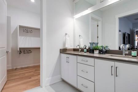 a white kitchen with a sink and a mirror at The Blair - Sunny Elegance, West End Luxury in Nashville