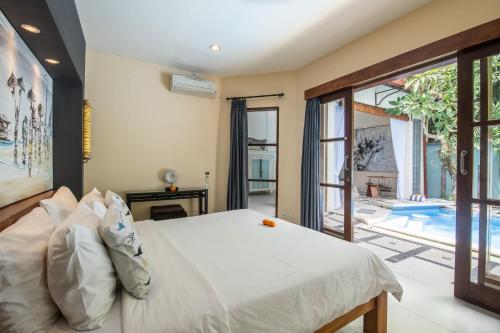 a bedroom with a bed and a swimming pool at Enigma Bali Villas Complex Canggu in Canggu